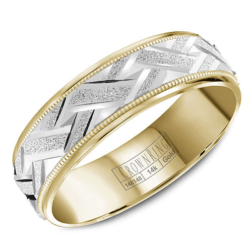 A yellow gold wedding band with a carved and textured white gold center and milgrain detailing.