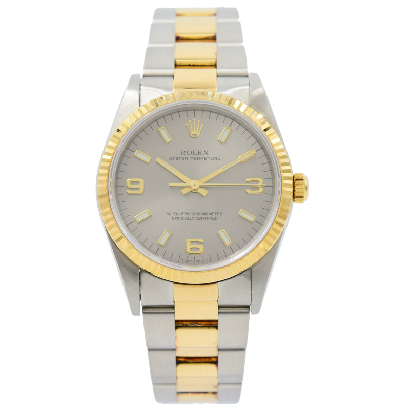 This Rolex Oyster Perpetual was recently traded in to our store and comes with the full box and papers. This piece is in very good condition and was just serviced in 2019. This watch still has the original sticker on the caseback, which is extremely unusual for a piece of this age. This model is two-tone with stainless steel and 18k yellow gold with a silver dial. The links do have some minor discoloration between them, which is normal for the age of this piece.