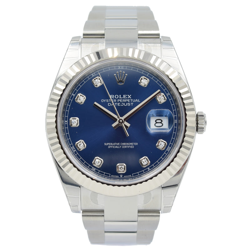 This Rolex Datejust 126334 was recently traded in to our store and is in very good condition. This watch still has most of the original stickers. This piece comes with the full box and papers. The watch features a 41mm stainless steel case with 18k white gold fluted bezel. The dial is blue with diamond indices.