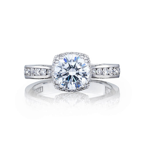 This unique round diamond engagement ring with a cushion bloom creates a look that is a beautiful juxtaposition of modern; yet traditional; classic; yet unconventional. The stunning center diamond is surrounded by a cushion shaped diamond bloom.