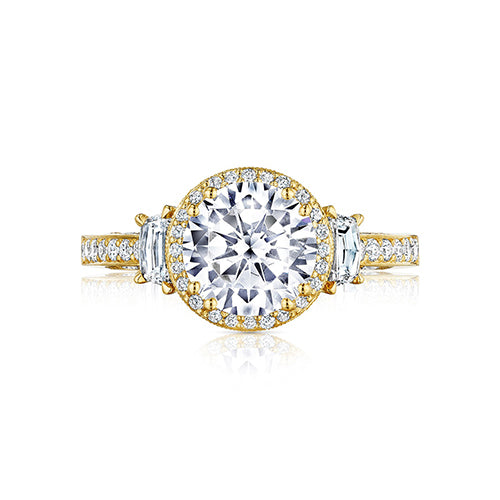 To celebrate the 10th Anniversary of our classic Dantela style; our designers are reintroducing it with a contemporary flair. With three times the charm; your round center is enhanced by a yellow gold and diamond bloom and brought to life by two high-inte