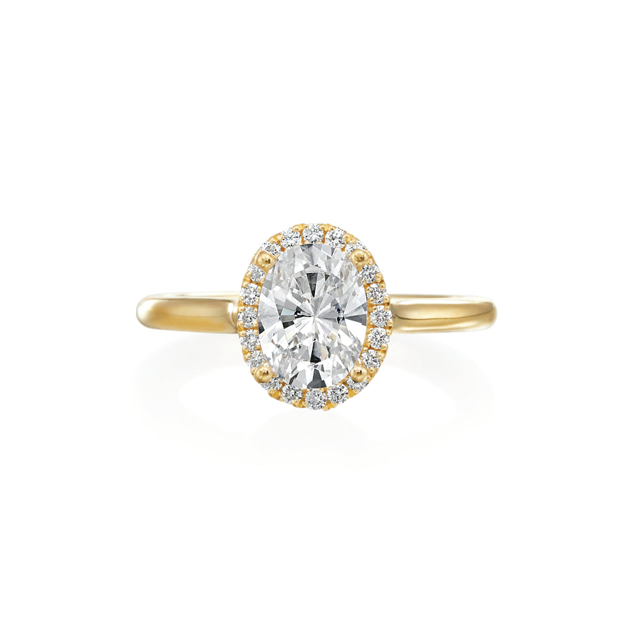 Designed with the intention of putting all of the spotlight on the center oval diamond, this ring is dainty and timeless. There are 0.21ctw diamonds in the halo and adorning the profile on both sides of the ring. Inside the shank, there is a small blue sapphire with the Moyer logo- a signature feature in all Moyer Collection engagement rings. Center stone is not included in the price. This ring can be made to fit any size or shape center diamond. 