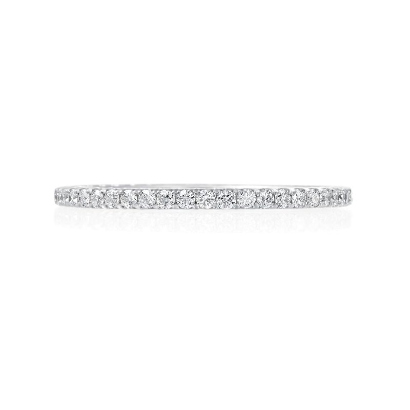 This 18K white gold Jack Kelege wedding band fits perfectly next to almost any engagement ring. Diamonds weighing 0.26 carat total weight travel half way around this wedding band. 