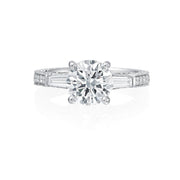 This Jack Kelege engagement ring has beautiful details from every angle. The center round brilliant diamond is framed by two baguette diamonds for a classic three-stone look. On the profile of the ring are intricate diamond, milgrain and etched details that will delight any bride to be! Center diamond is not included in the price shown. 