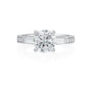 This Jack Kelege engagement ring has beautiful details from every angle. The center round brilliant diamond is framed by two baguette diamonds for a classic three-stone look. On the profile of the ring are intricate diamond, milgrain and etched details that will delight any bride to be! Center diamond is not included in the price shown. 