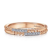 One of the most unique band designs in the Gabriel & Co. collection, this 14K rose gold wedding band features beading and diamonds in an intriguing pattern. Stack this band in with your existing wedding bands! 