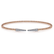 The allure of this bangle starts with the beads. The beautiful 14K gold rose color of beads for this bracelet will match any skin tone and any outfit. Two spikes of shimmering pav diamonds finish the bracelet in a sparkling display. Grab attention (and keep it) with this lovely bangle.
