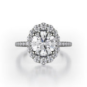 The graduated size of the diamonds in the halo of this 18K white gold engagement ring give the ring the appearance of an oval diamond even though the center stone is round brilliant. There are 0.55ctw diamonds in the halo and on the shank of the engagement ring. Those diamonds are G-H in color, SI1-2 in clarity. The metalwork under the head of the engagement ring is exquisite, giving the wearer a beautiful profile to peek at. The center stone is not included in the price. This engagement ring ca