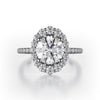 The graduated size of the diamonds in the halo of this 18K white gold engagement ring give the ring the appearance of an oval diamond even though the center stone is round brilliant. There are 0.55ctw diamonds in the halo and on the shank of the engagement ring. Those diamonds are G-H in color, SI1-2 in clarity. The metalwork under the head of the engagement ring is exquisite, giving the wearer a beautiful profile to peek at. The center stone is not included in the price. This engagement ring ca